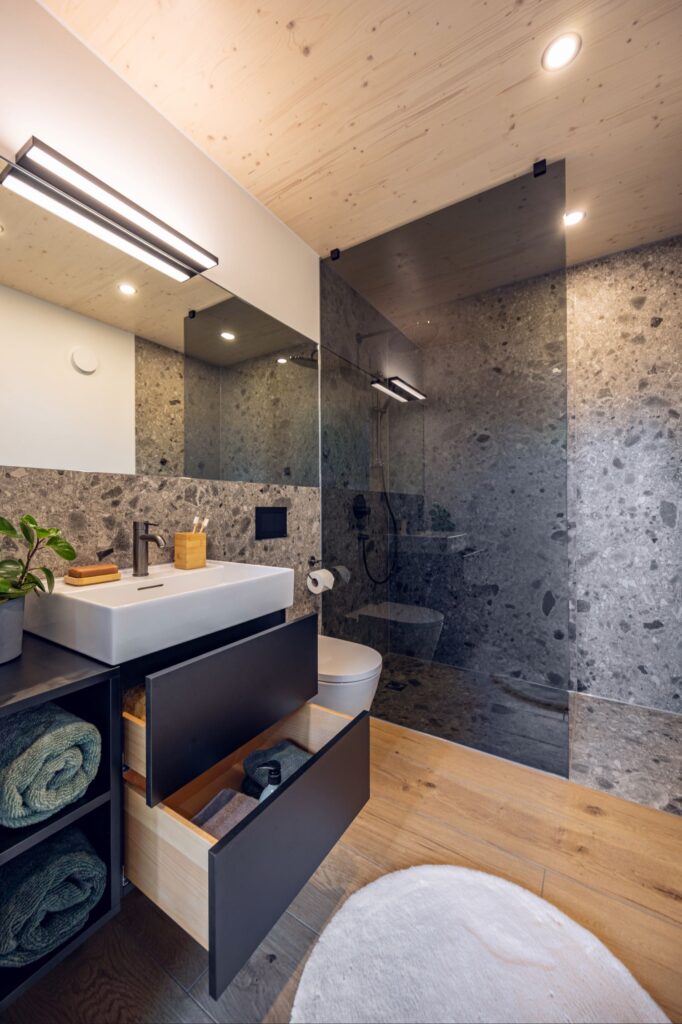 Tjiko-Badezimmer aus dem Projekt Sommit: WC, Dusche und Waschbecken mit schwarzer Armatur, Designlinie Zermatt.