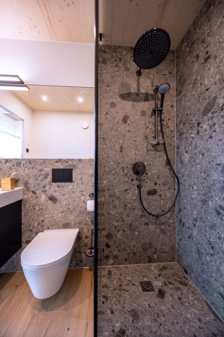 Tjiko-Badezimmer aus dem Projekt Sommit: WC und Dusche mit schwarzer Armatur.