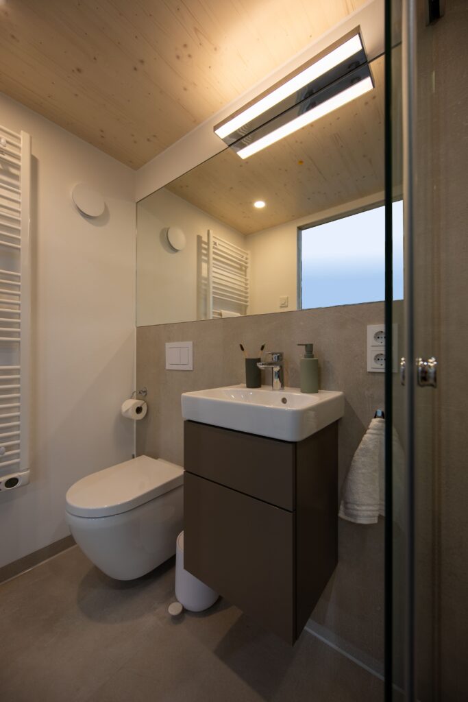 Badezimmer Inverness: Ausschnitt zeigt WC und Waschbecken mit chromfarbener Armatur.