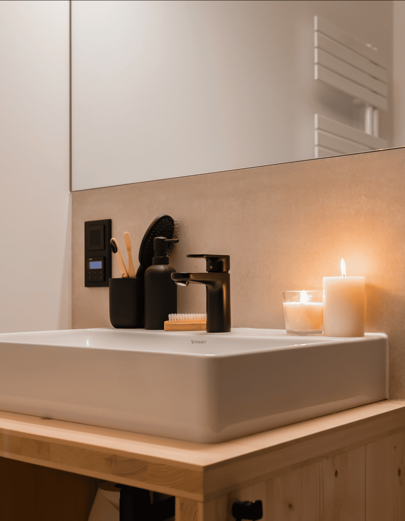 Badezimmer Osaka: Ausschnitt zeigt Waschbecken mit schwarzer Armatur im Kerzenschein.