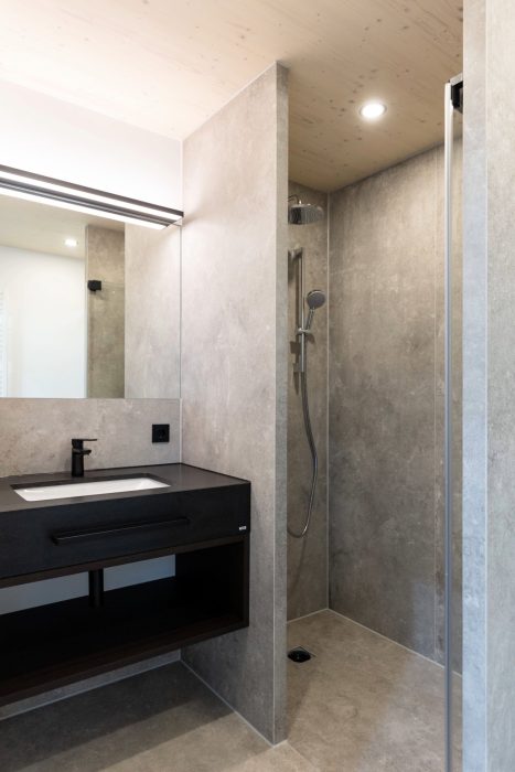 Badezimmer Osaka: Ausschnitt zeigt Dusche und Waschbecken mit schwarzer Armatur.