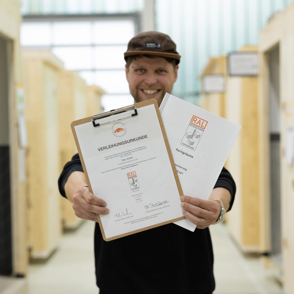 Mitarbeiter mit Verleihungsurkunde von RAL-Gütezeichen